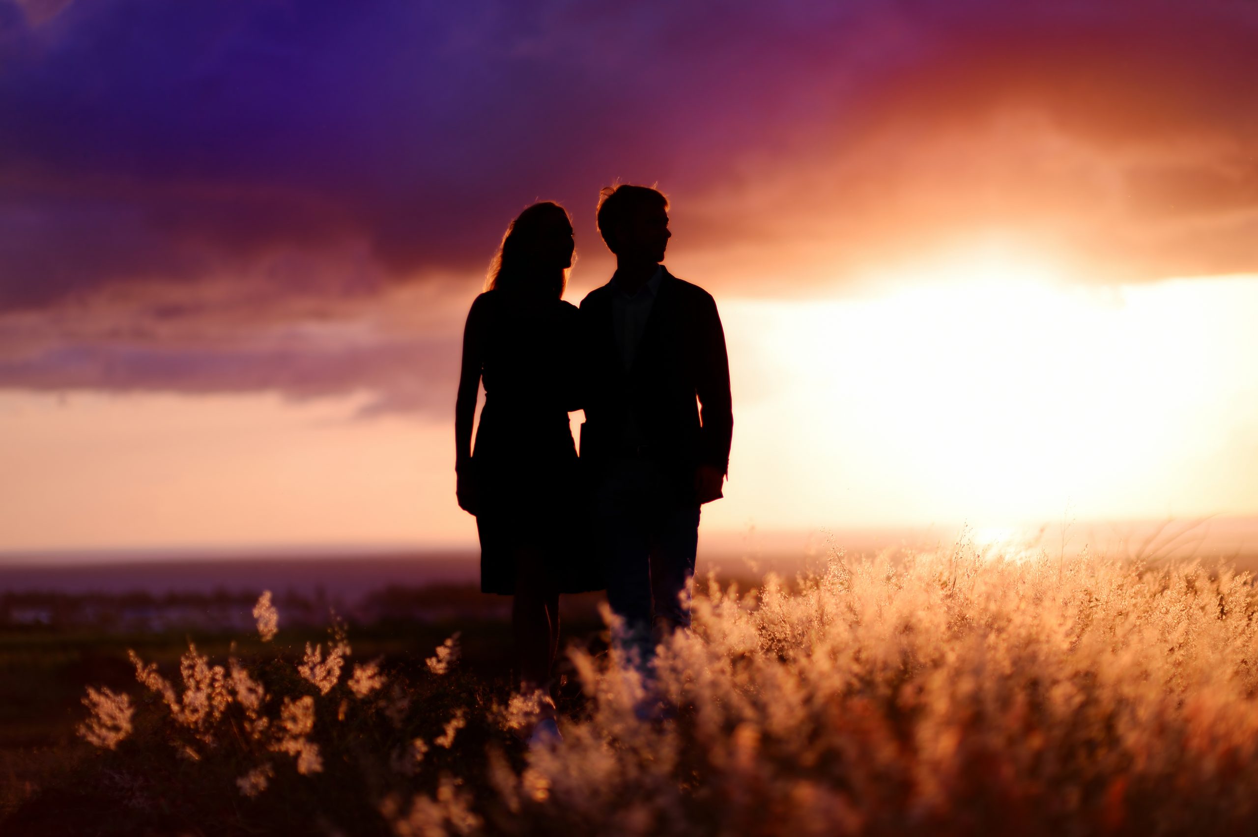 Young,Couple,Enjoying,The,Sunset,In,The,Meadow